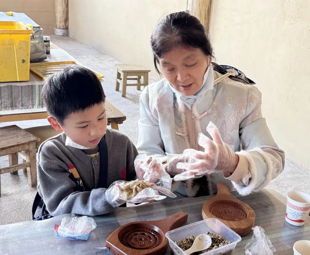 游客体验制作纳西喜饼。(丽江融媒记者 张小秋 摄)