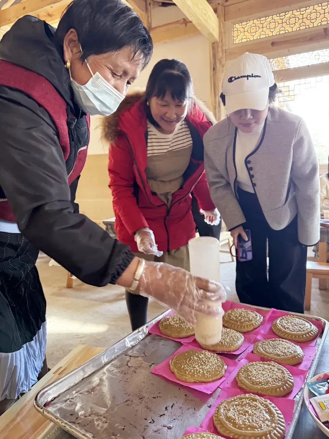 游客体验制作纳西喜饼。(丽江融媒记者 张小秋 摄)